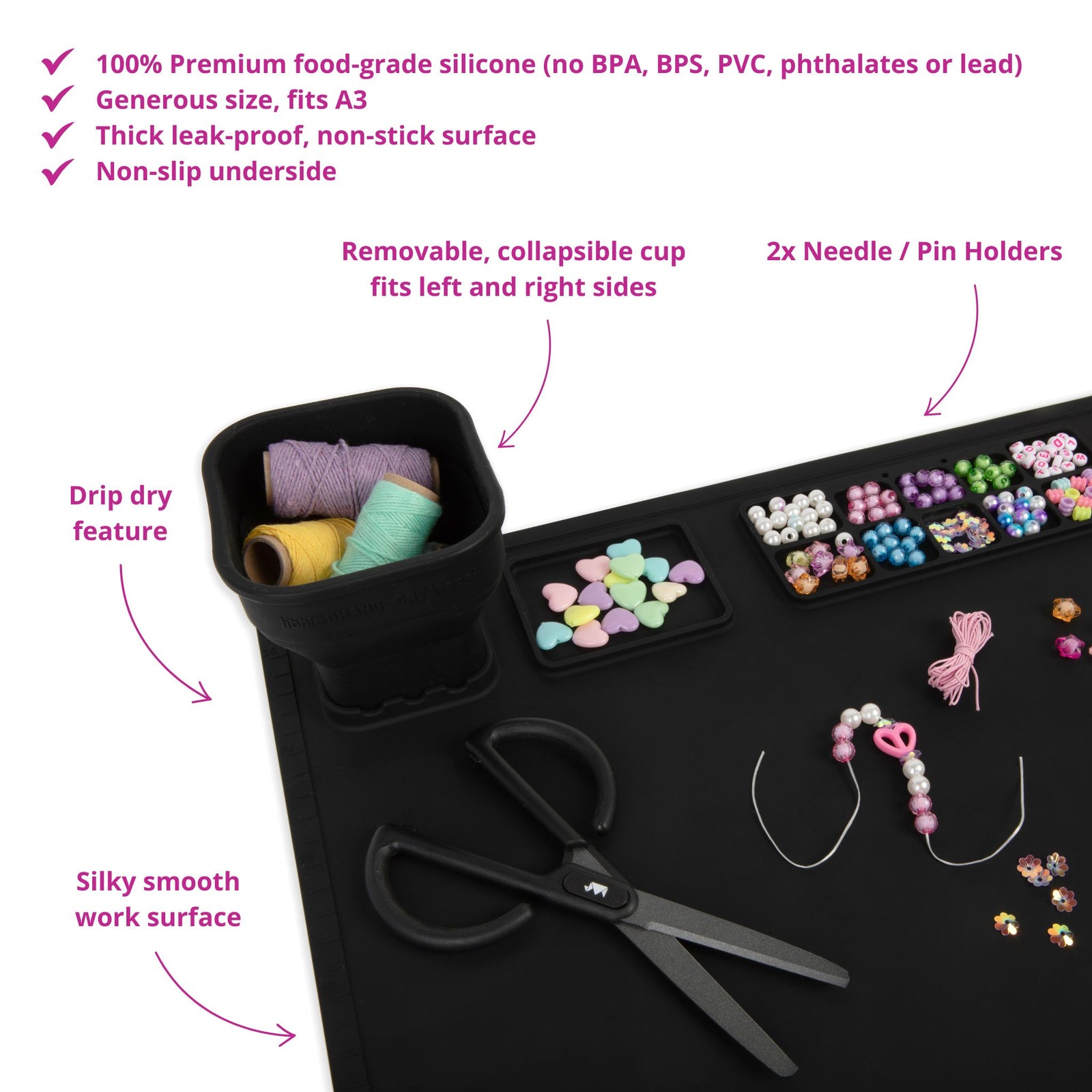 A black silicone craft mat with collapsible cup and in-built palette. In this image, the mat is being used for jewellery making and shows scissors, thread and beads on the mat.