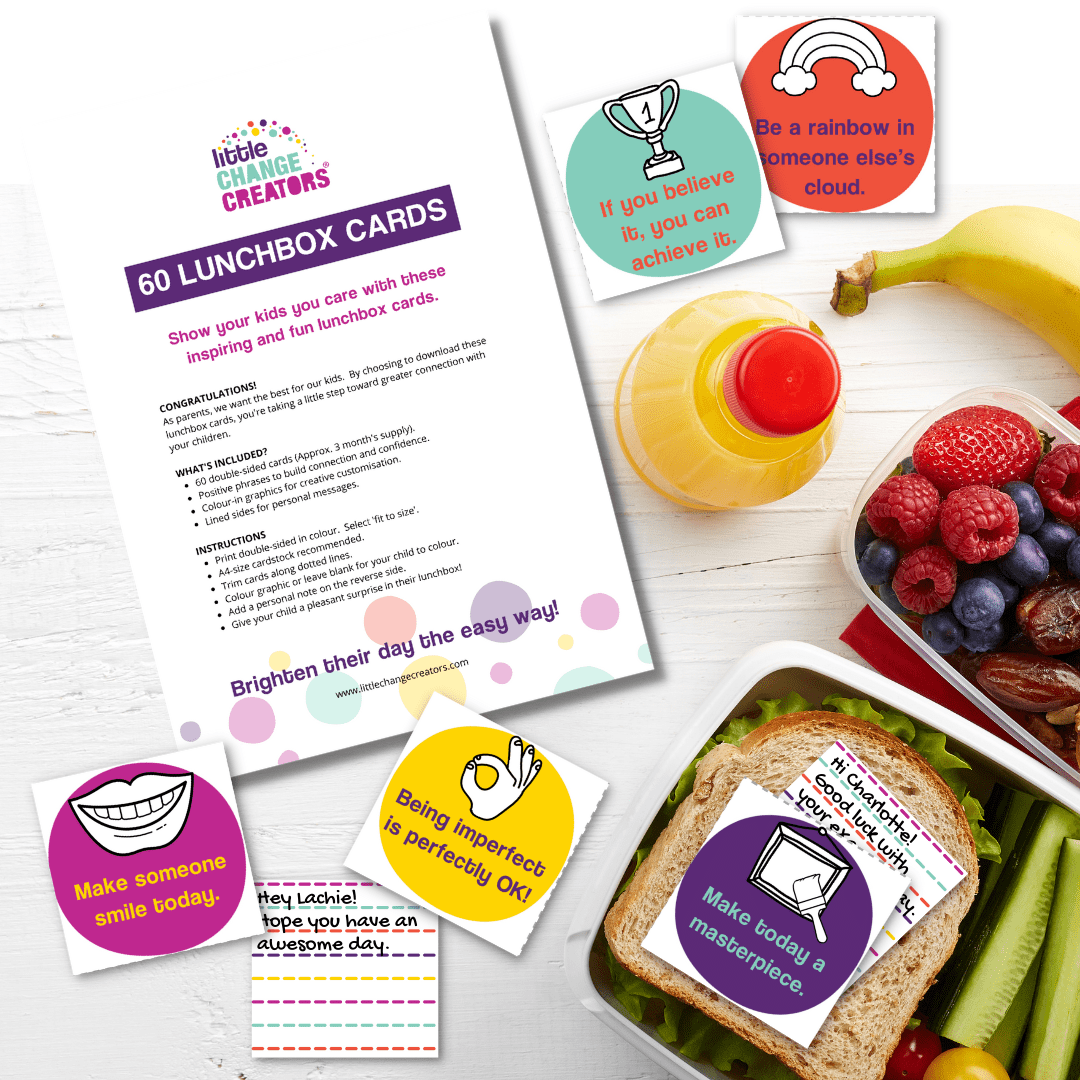 Lunchbox cards with motivational messages on a table with a sandwich, juice, and fruit.