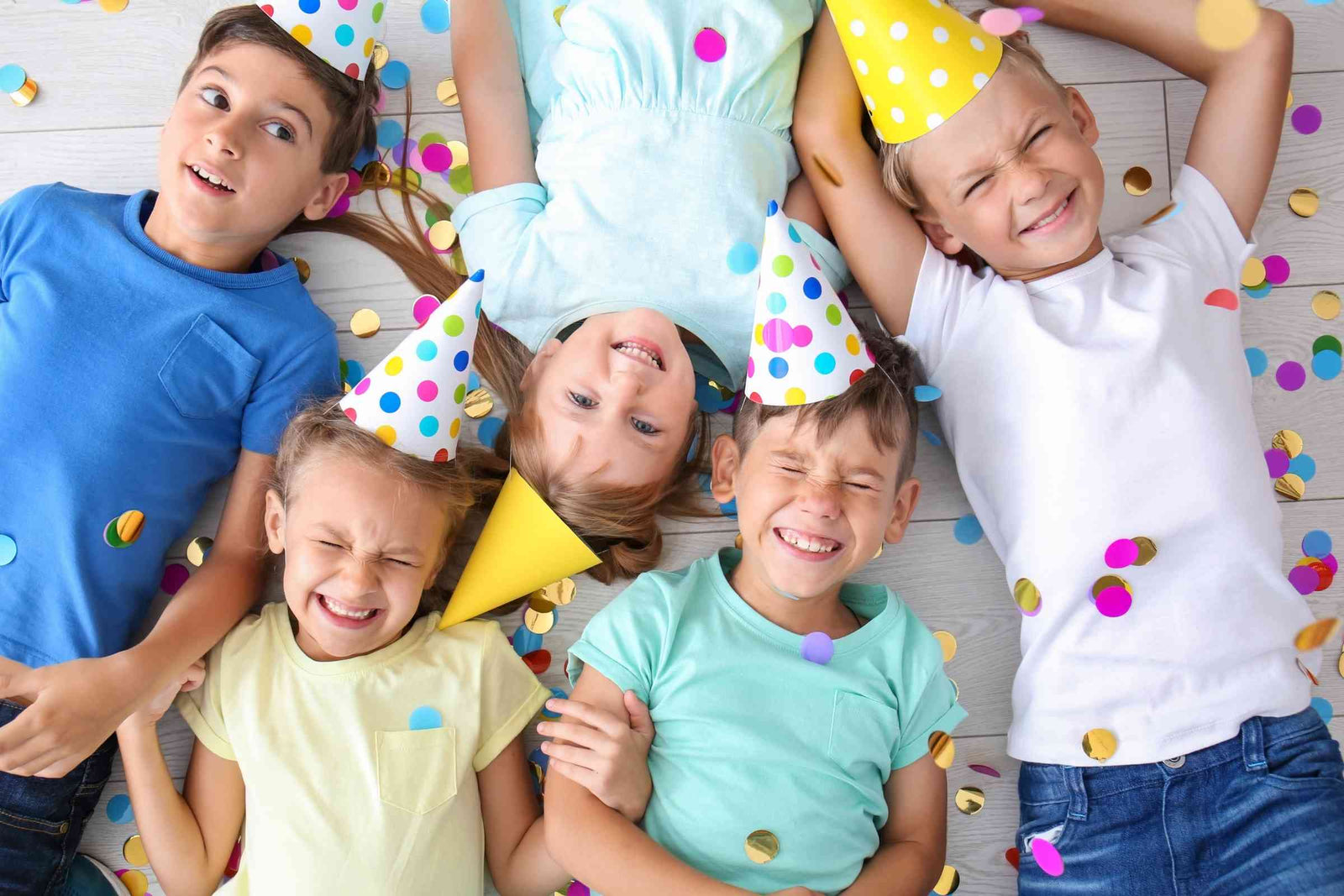 Creative kids laying down with confetti