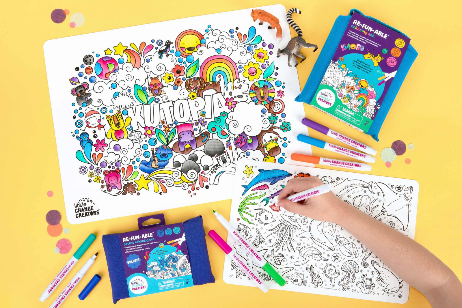 Wipeable silicone colouring mats in two sizes with cute animal illustrations.  The image includes packaging and loose markers on a yellow background.
