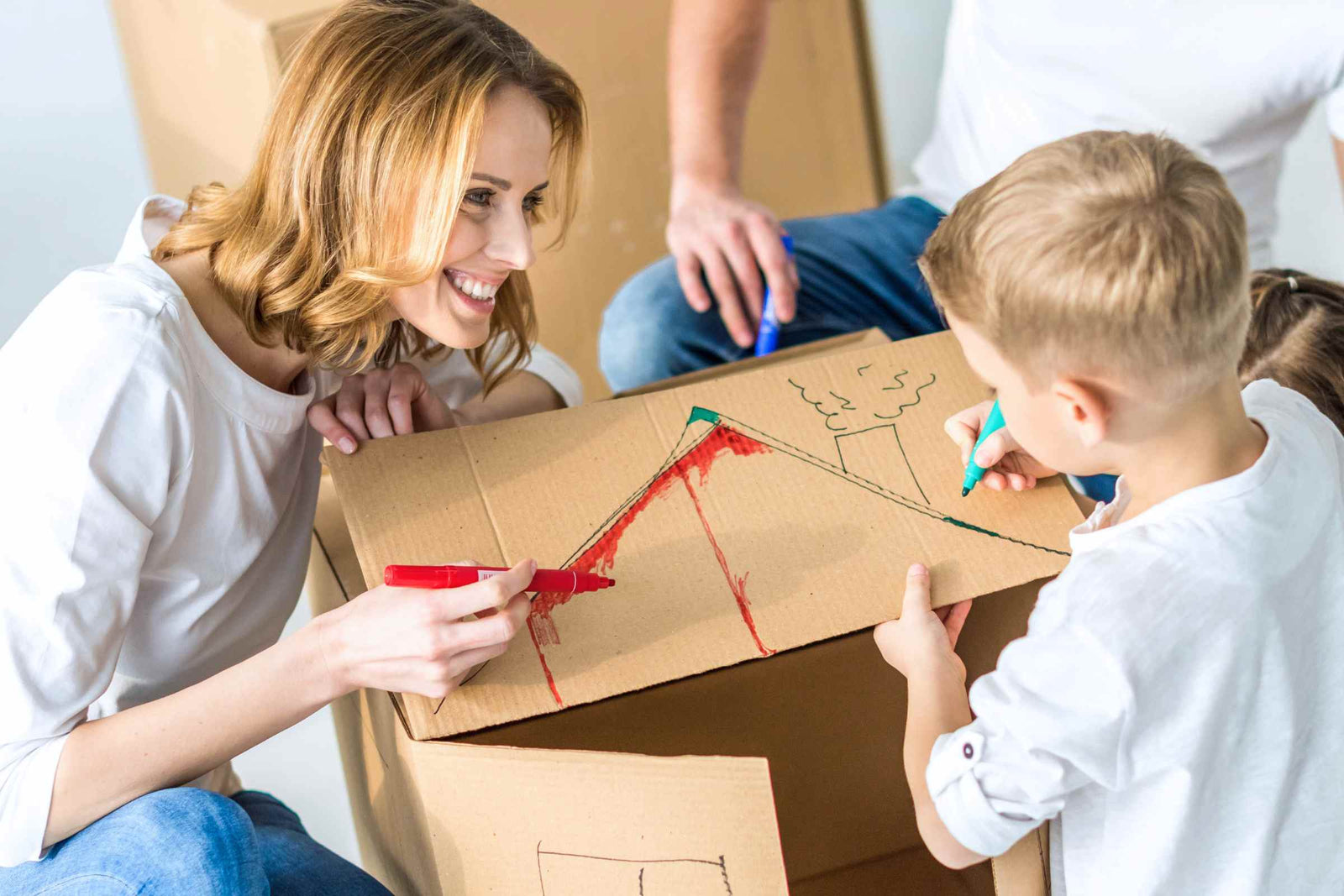 A mother connects with her child through a craft activity using cardboard and paint.