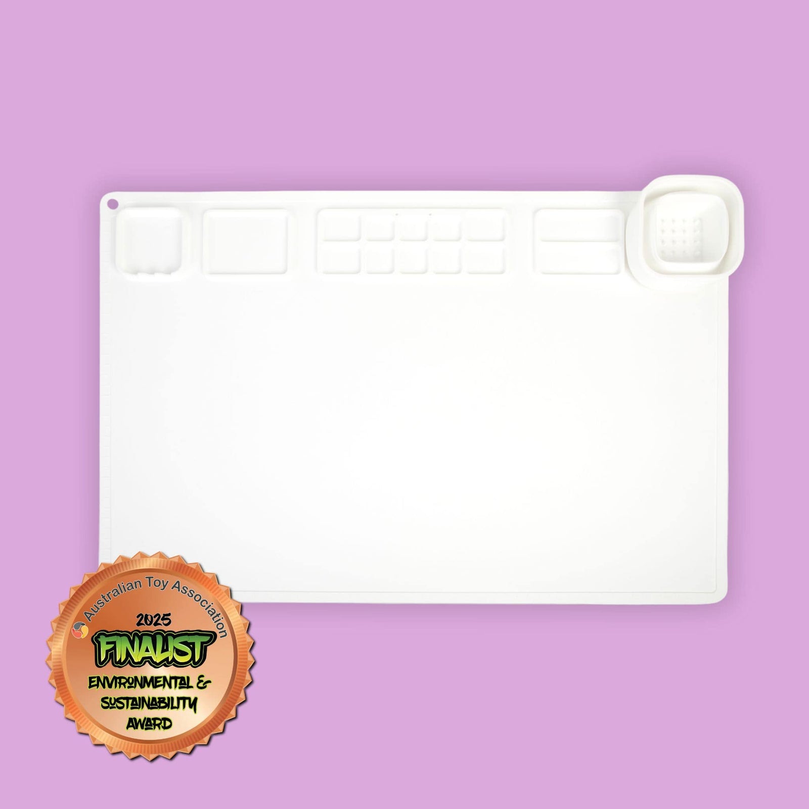 A large white silicone painting and craft mat with collapsible cup and in-built palette. Image includes Environmental & Sustainability Award from the Australian Toy Association.