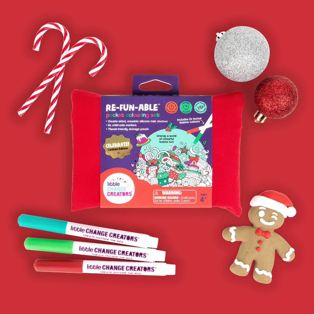 Christmas colouring set with markers, candy canes, and a gingerbread man on a red background.