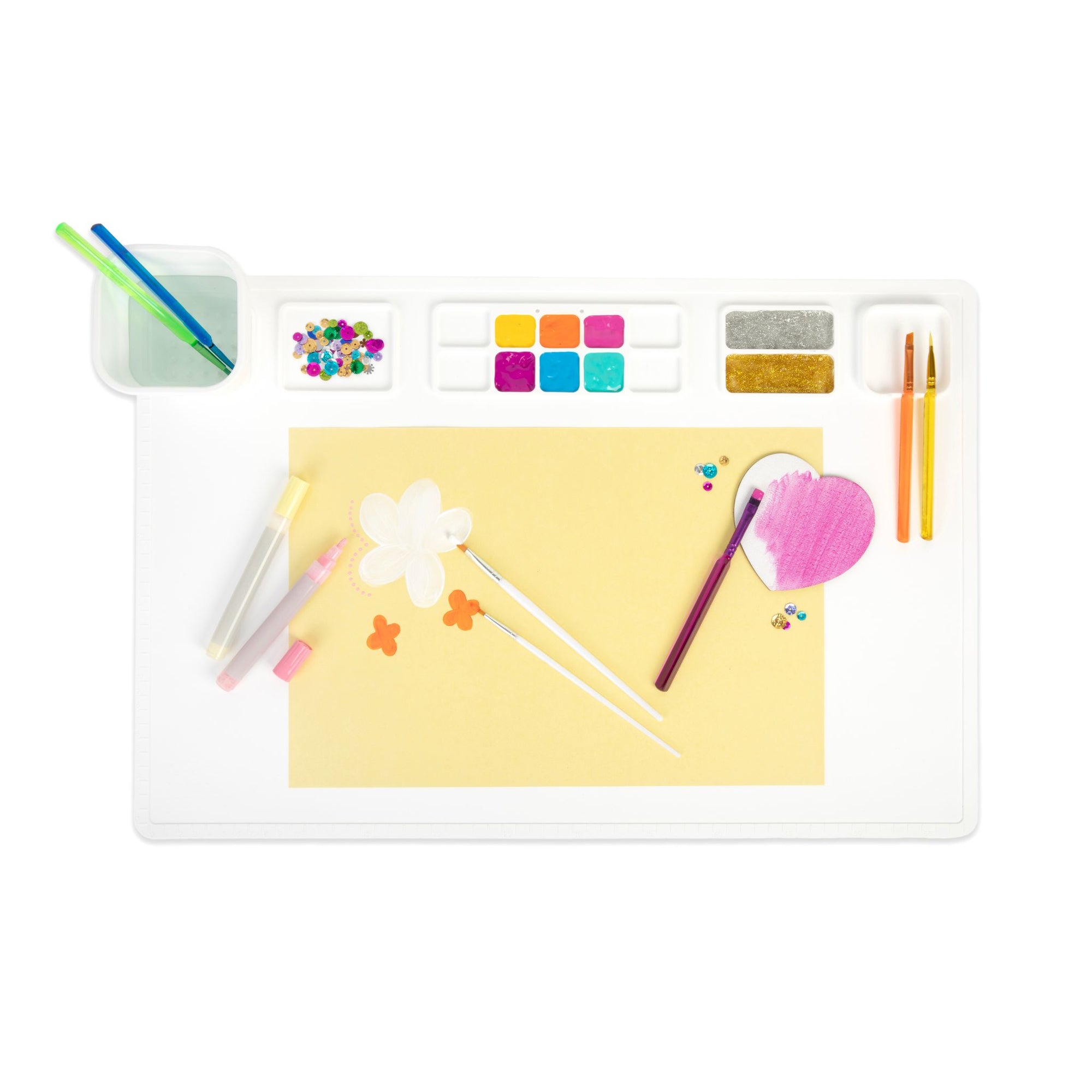 Image shows a large white paint mat with multi-coloured paints, paintbrushes and children's craft supplies.