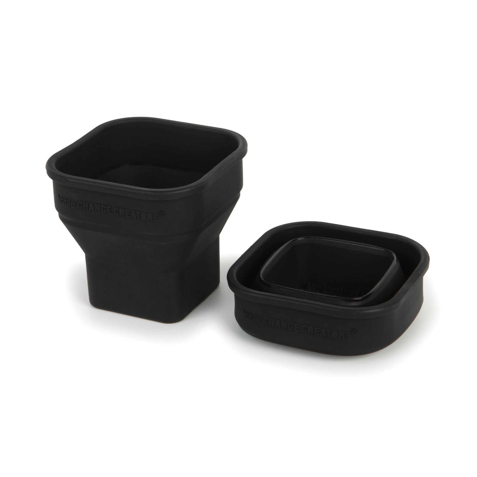 The image shows two black silicone cups that can flatten.  The cup on the left is upright and the cup on the right has been collapsed.