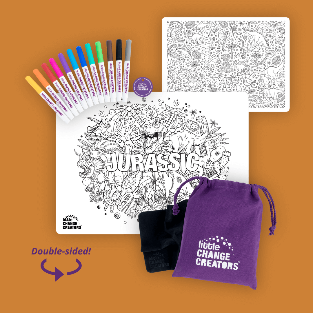 A double-sided silicone colouring mat featuring dinosaurs.  It has the word Jurassic on the front side and lots of dinosaurs on the reverse side.  The image also shows 12 coloured markers and a purple fabric bag with a Little Change Creators logo.