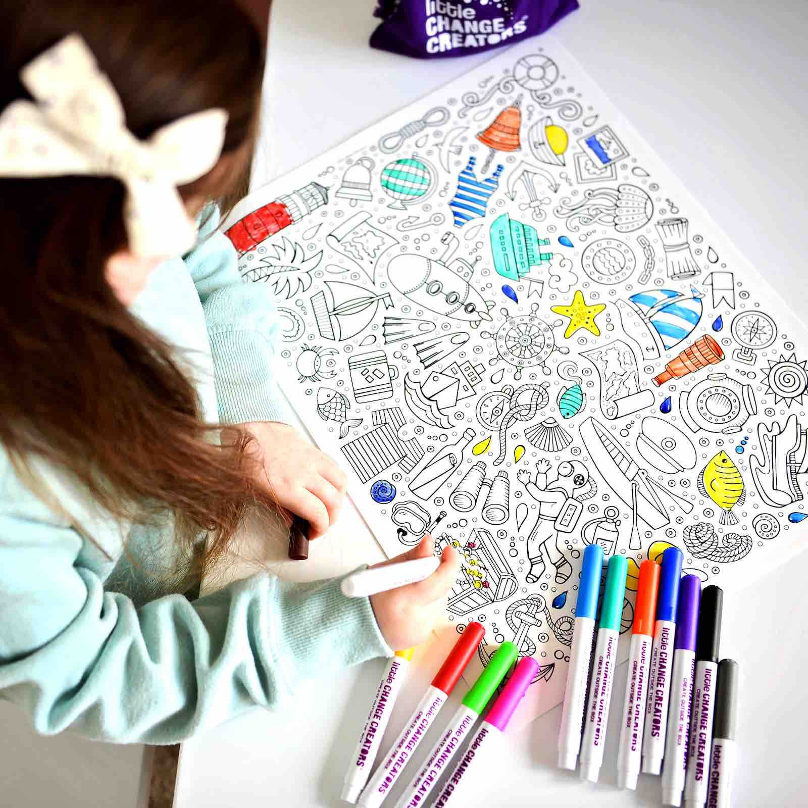 Image of young girl colouring in Seaside theme reusable colouring mat